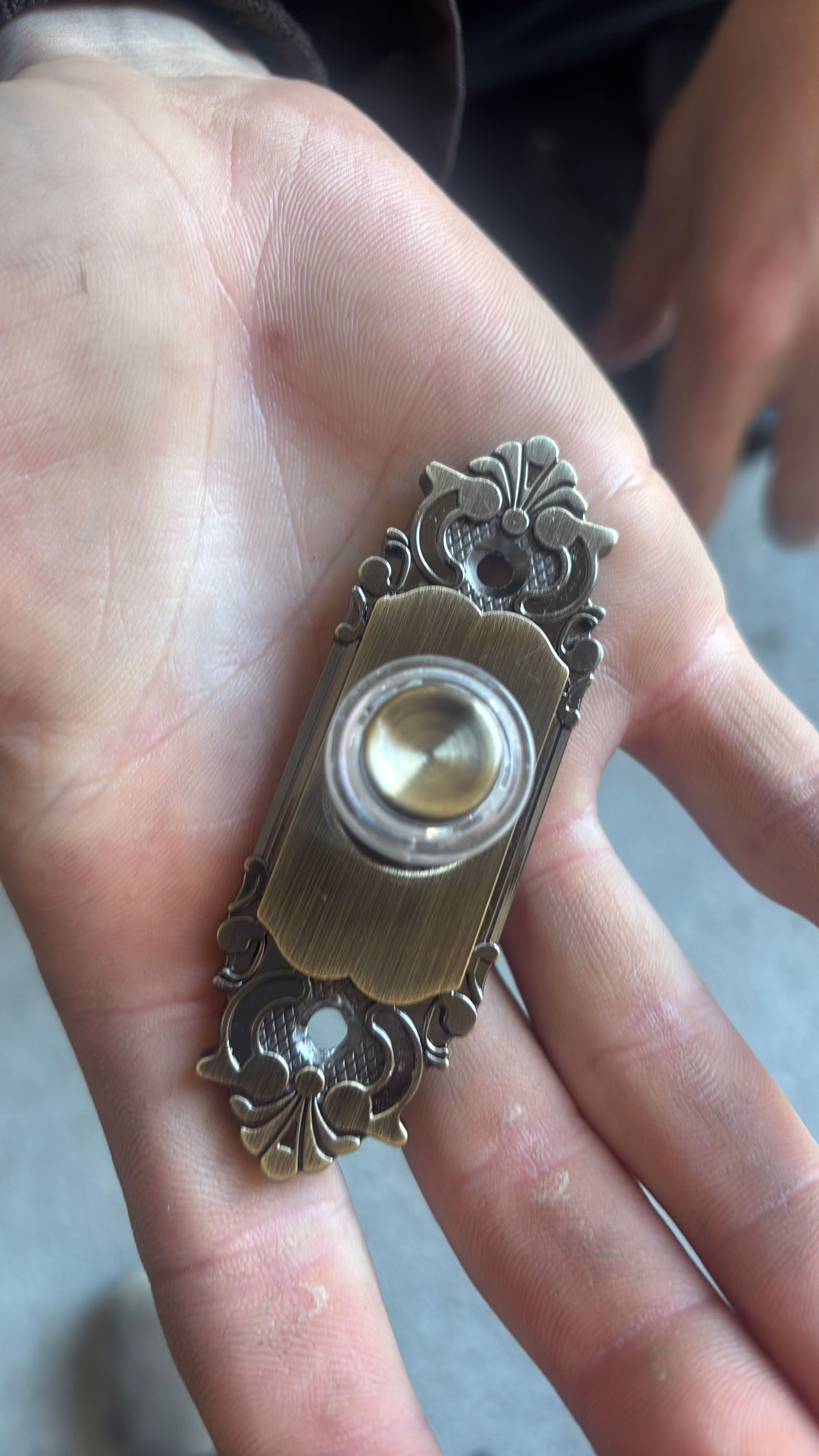 Vintage ornate brooch with a pearl center resting in an open palm