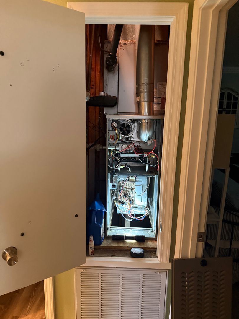 Open closet showing exposed plumbing, wiring, and equipment inside a wall cavity