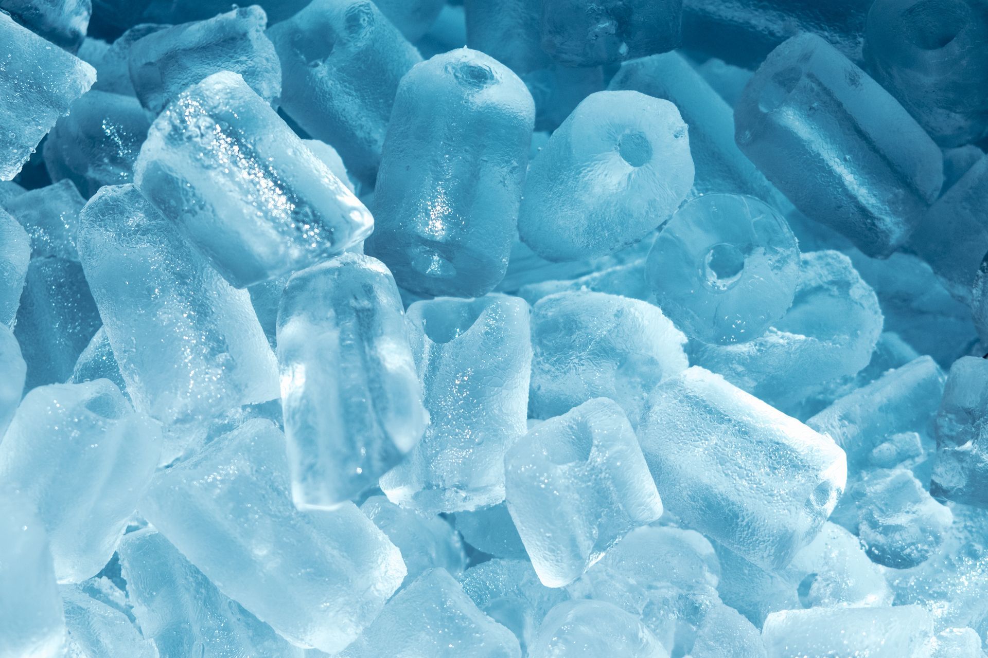 Pile of translucent blue ice cubes and crushed ice