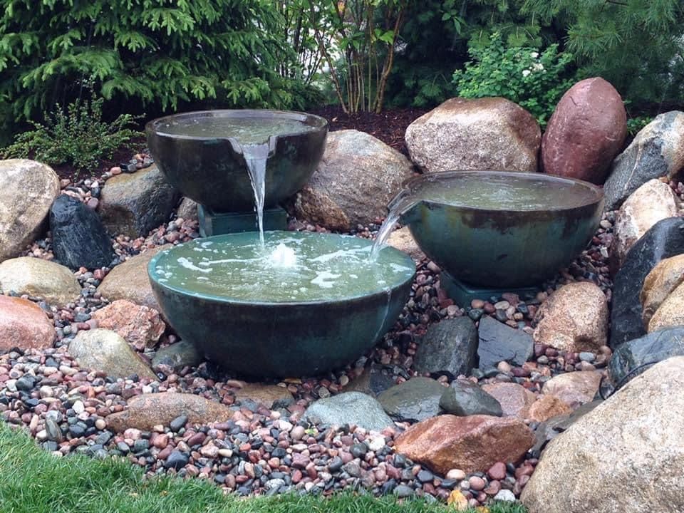 A man in a hat is kneeling in a pond