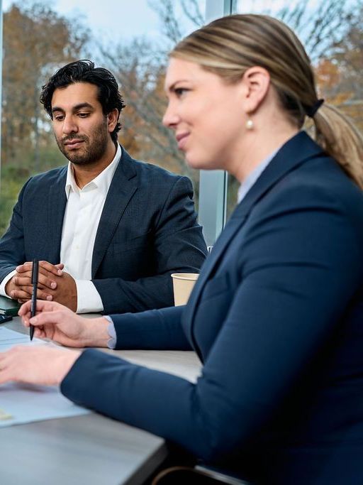 A man and a woman are sitting at a table having a meeting.