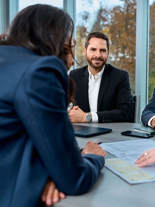 A group of people are sitting around a table having a meeting.