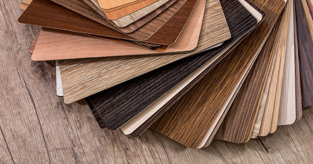 A variety of wood samples are stacked on top of each other on a wooden table.