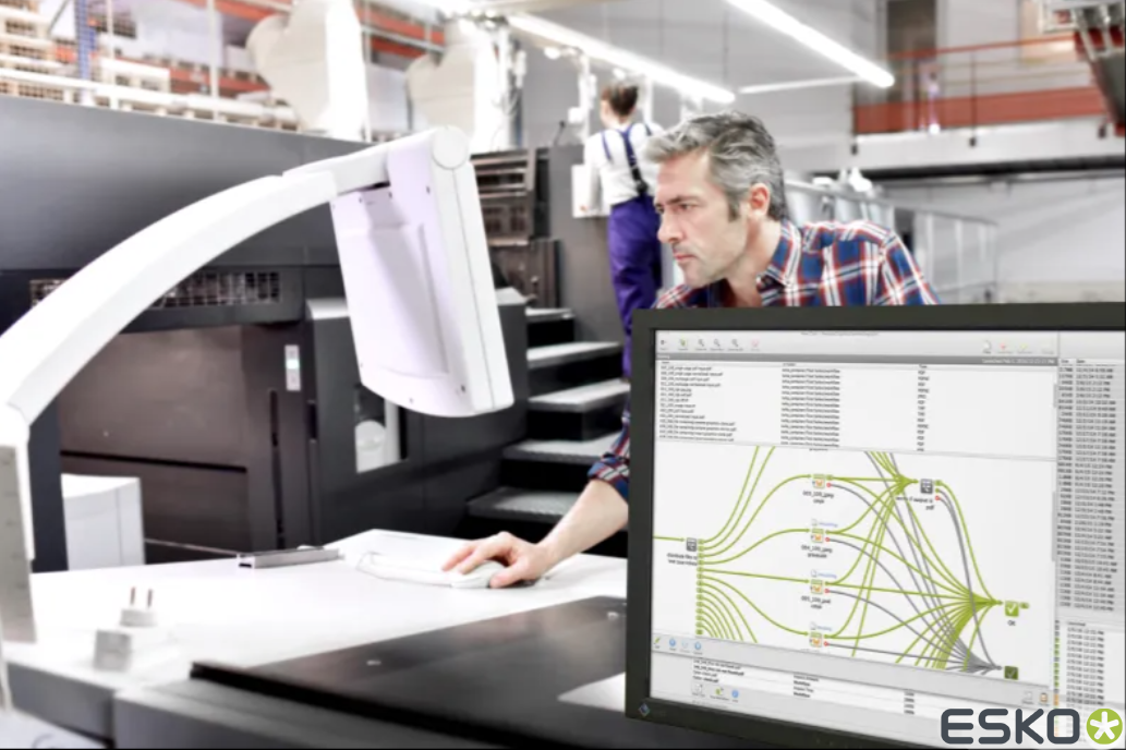 A man is looking at a computer screen that says esko on it