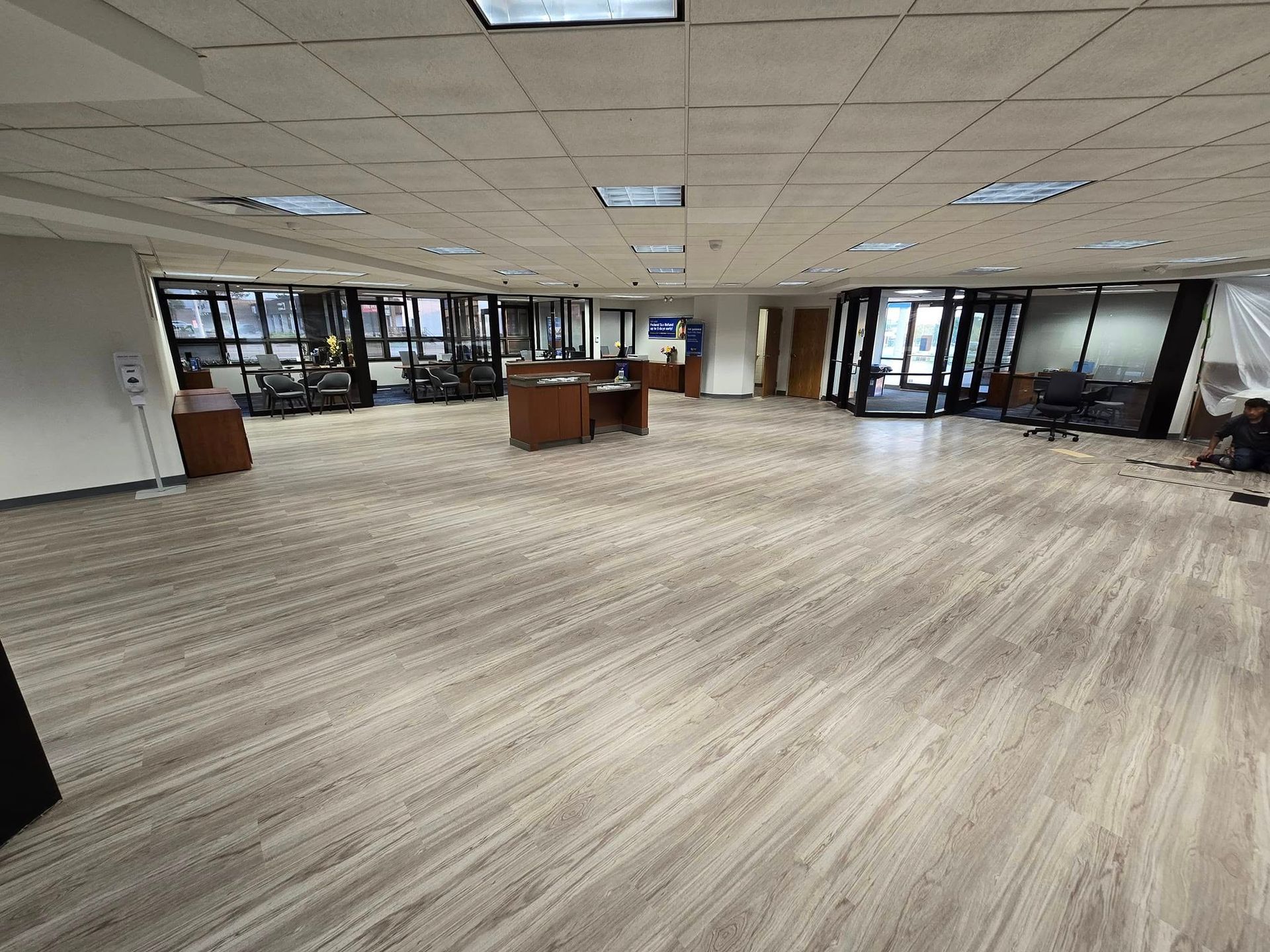 A large room with a wooden floor and a lot of windows.