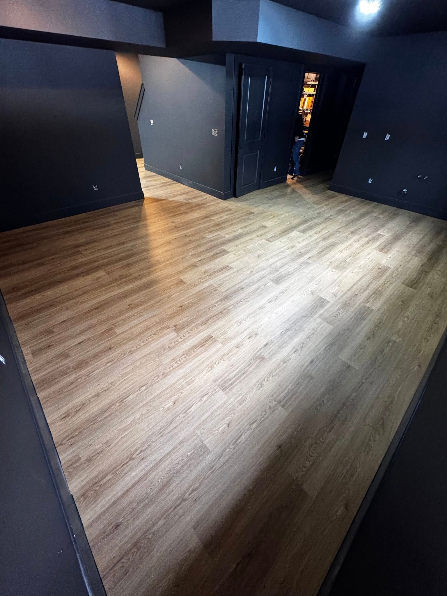 A room with a wooden floor and black walls.