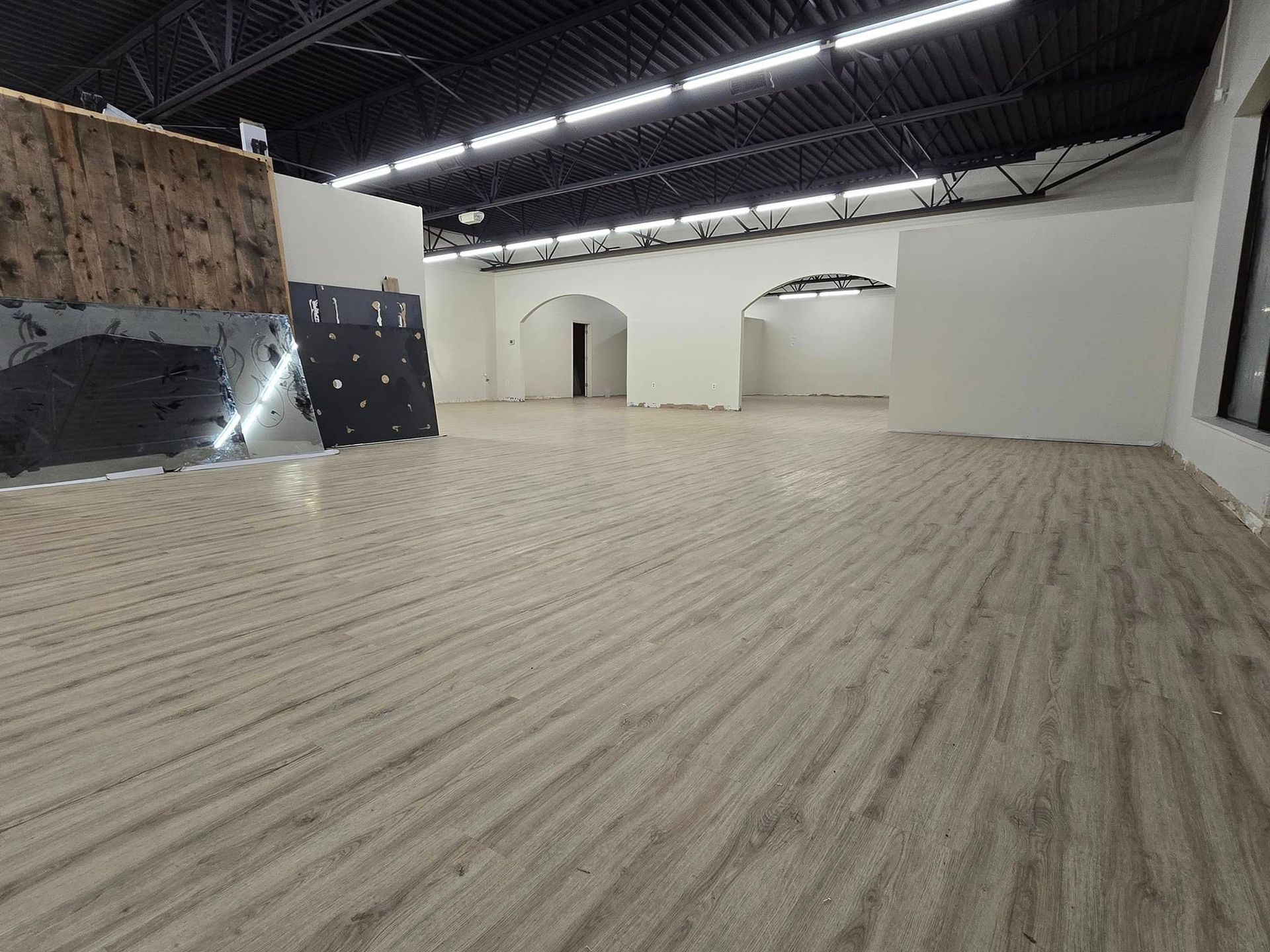 A large empty room with a wooden floor and white walls.