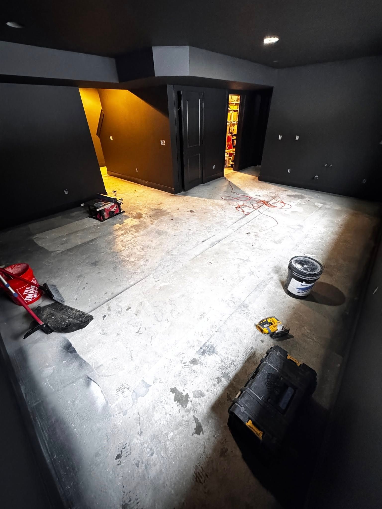 A room with a bucket and a toolbox on the floor.