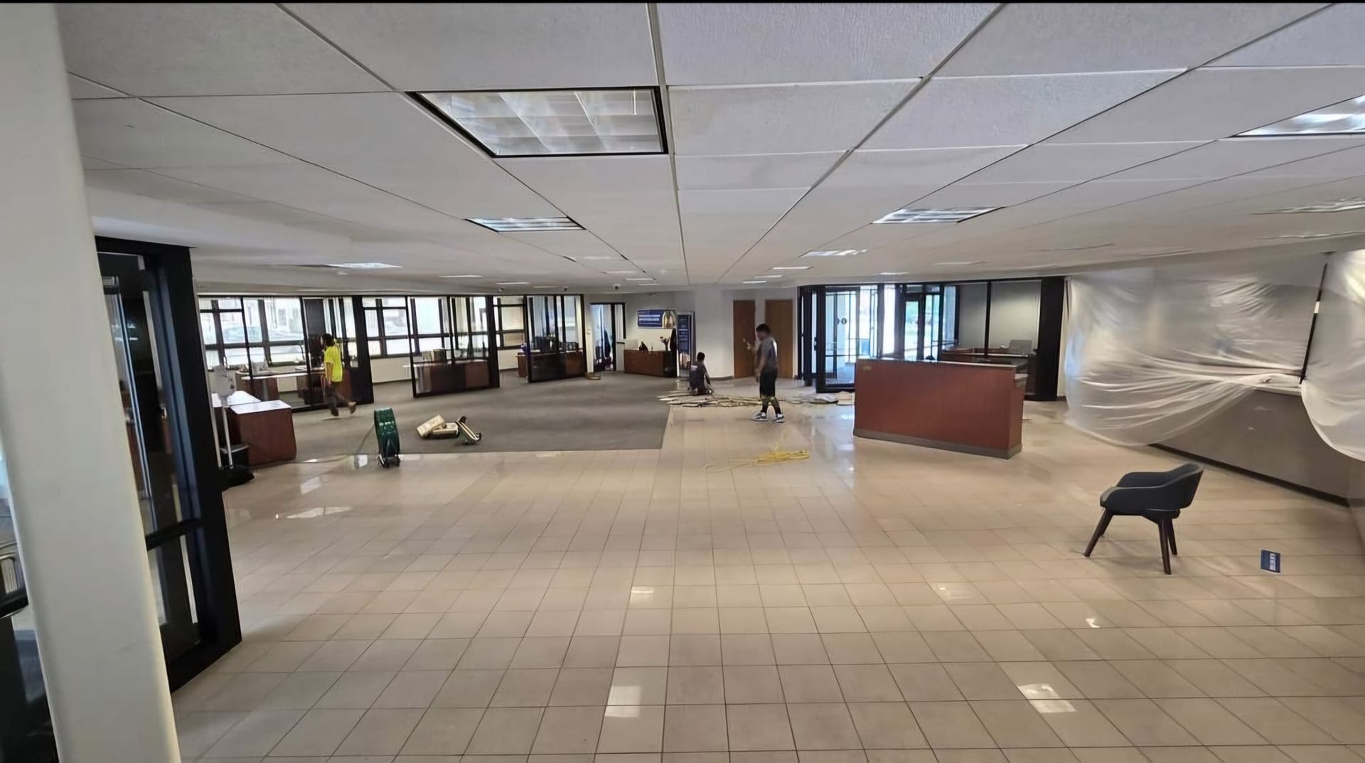 A large empty room with a chair in the middle of it.