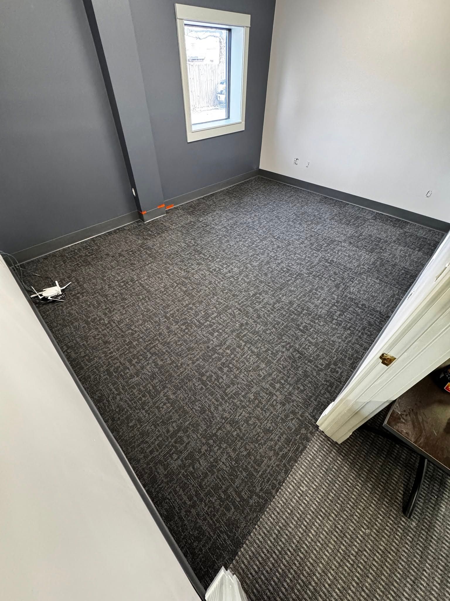 A room with a carpeted floor and a window.