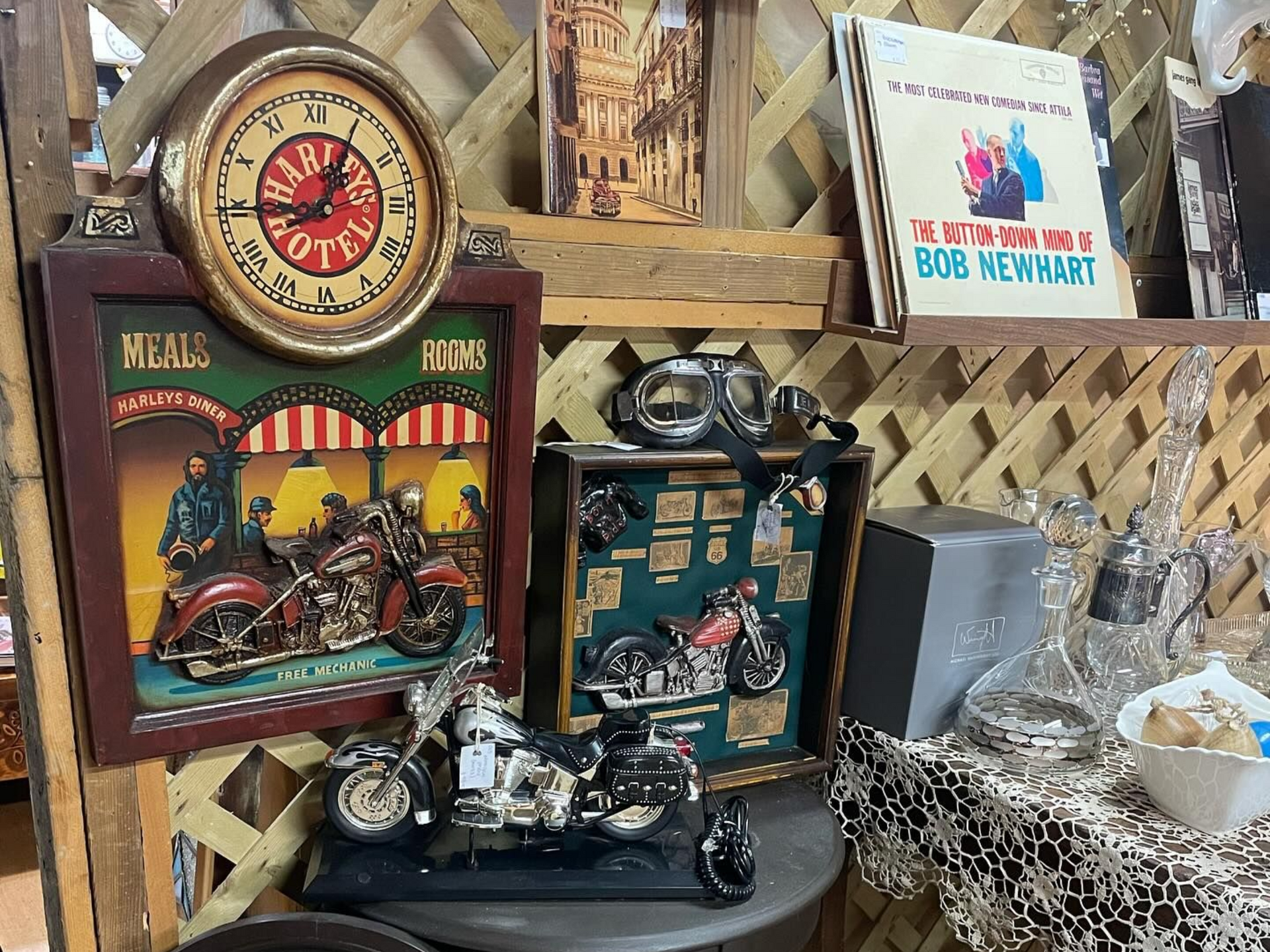 Antique-style market display with vintage clocks, decorative tins, and assorted curios on a shelf.