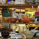 Shelves of colorful glass bowls and decorative dishes in a shop display