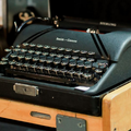 Black vintage typewriter on a wooden desk tray