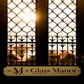 Sunlight through ornate wrought-iron window at Glass Manor wedding venue sign