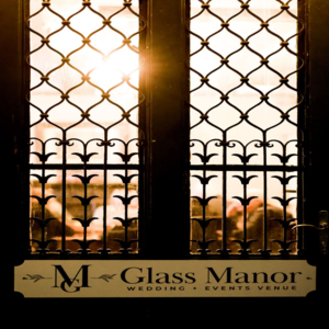 Sunlight through ornate wrought-iron window at Glass Manor wedding venue sign