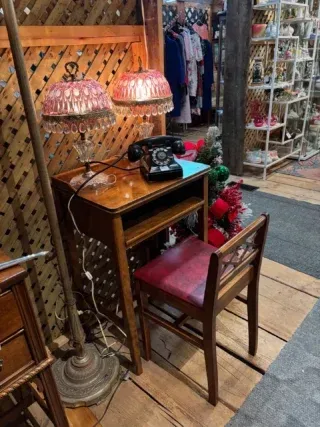 Vintage wooden desk with pink lamps and a typewriter in a cozy shop display