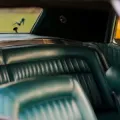 Green leather car seats and rear window with a small horse decal inside a vintage vehicle