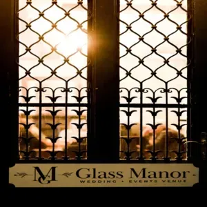 Sunlit wrought-iron windows at Glass Manor Wedding and Events Place sign at the bottom