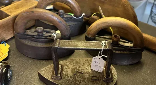 Three vintage metal and wooden door handles on display with price tags.
