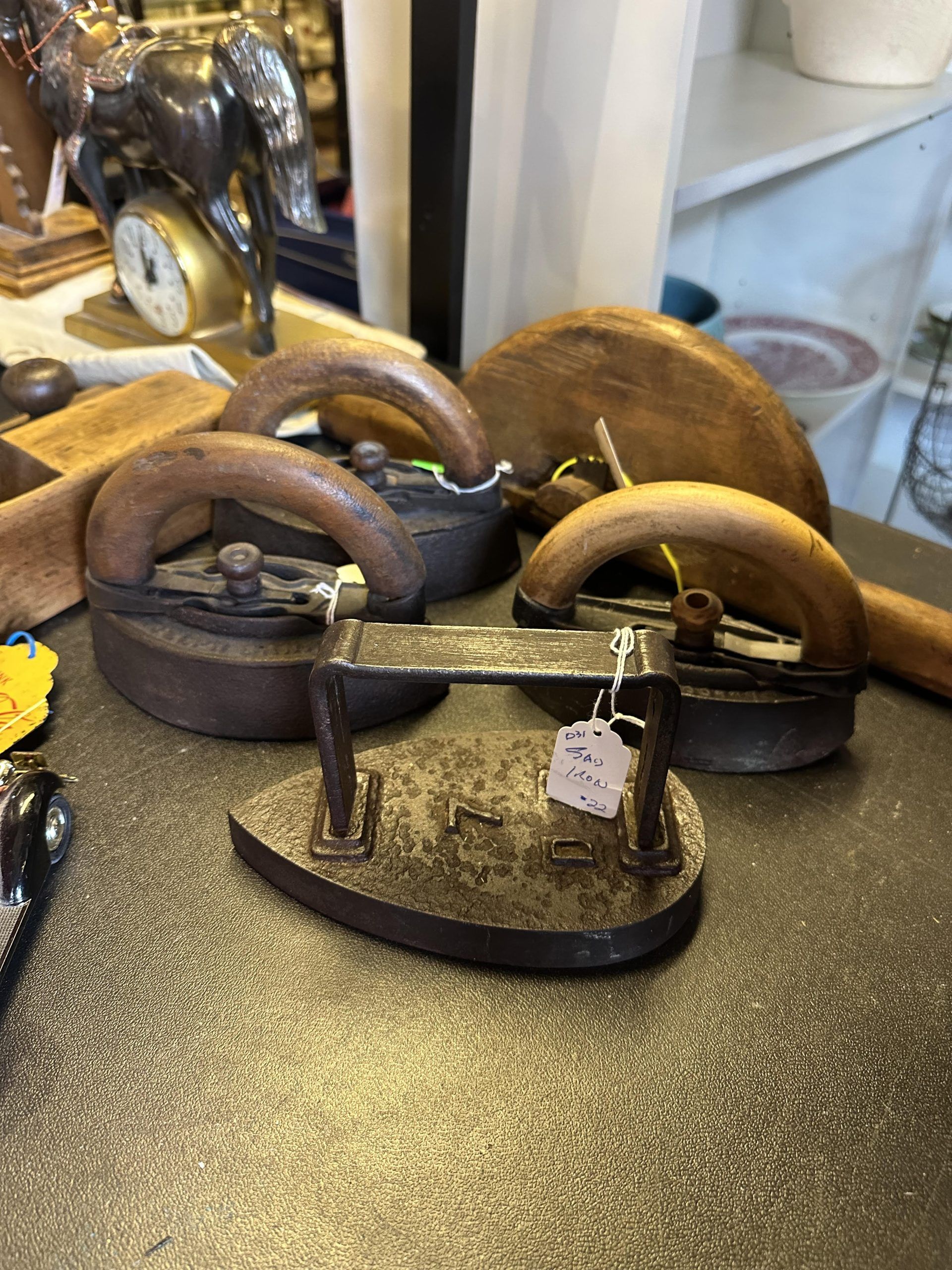 Three vintage metal and wooden door handles on display with price tags.