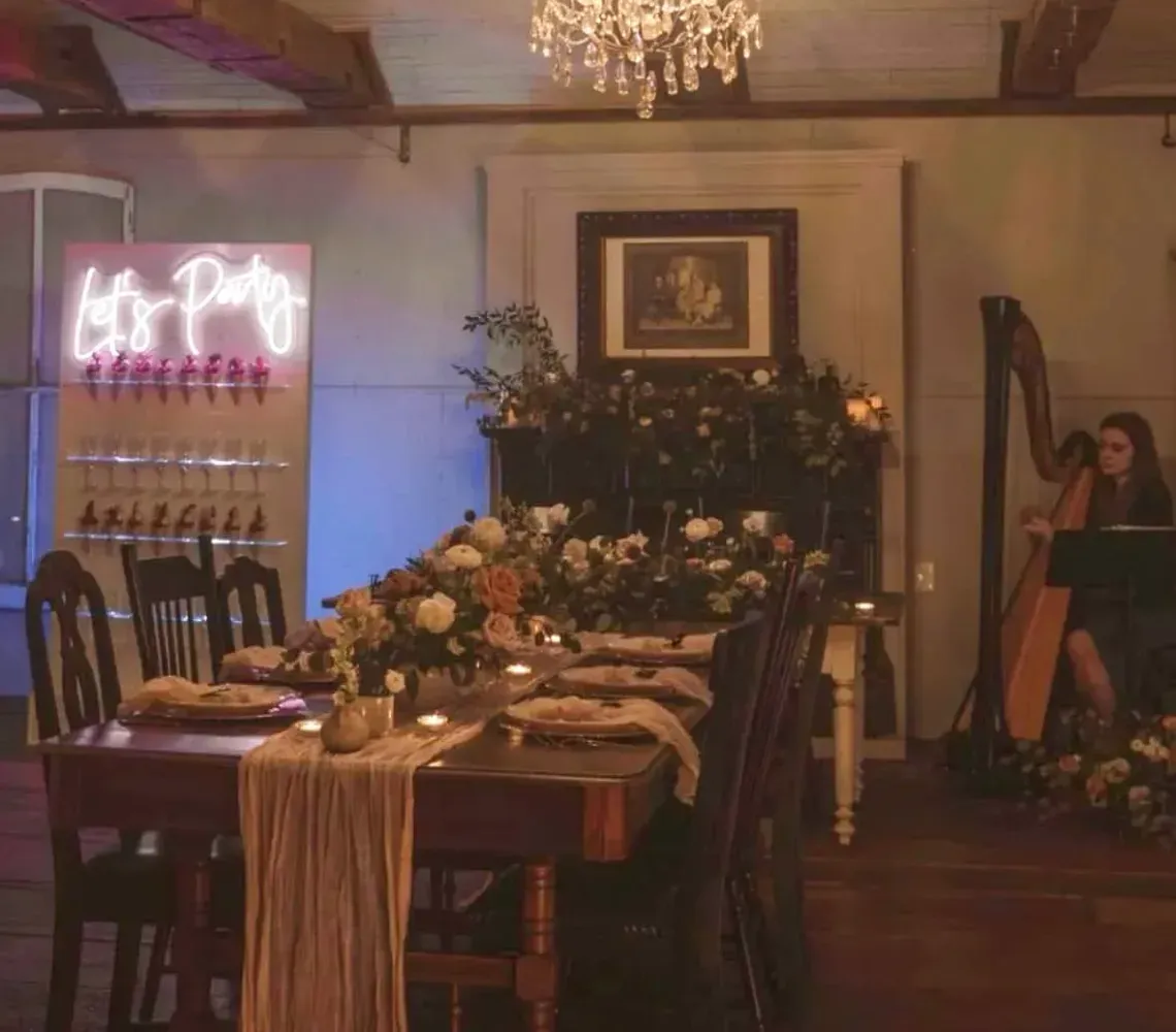 Elegant dining room with chandelier, long decorated table, and warm ambient lighting