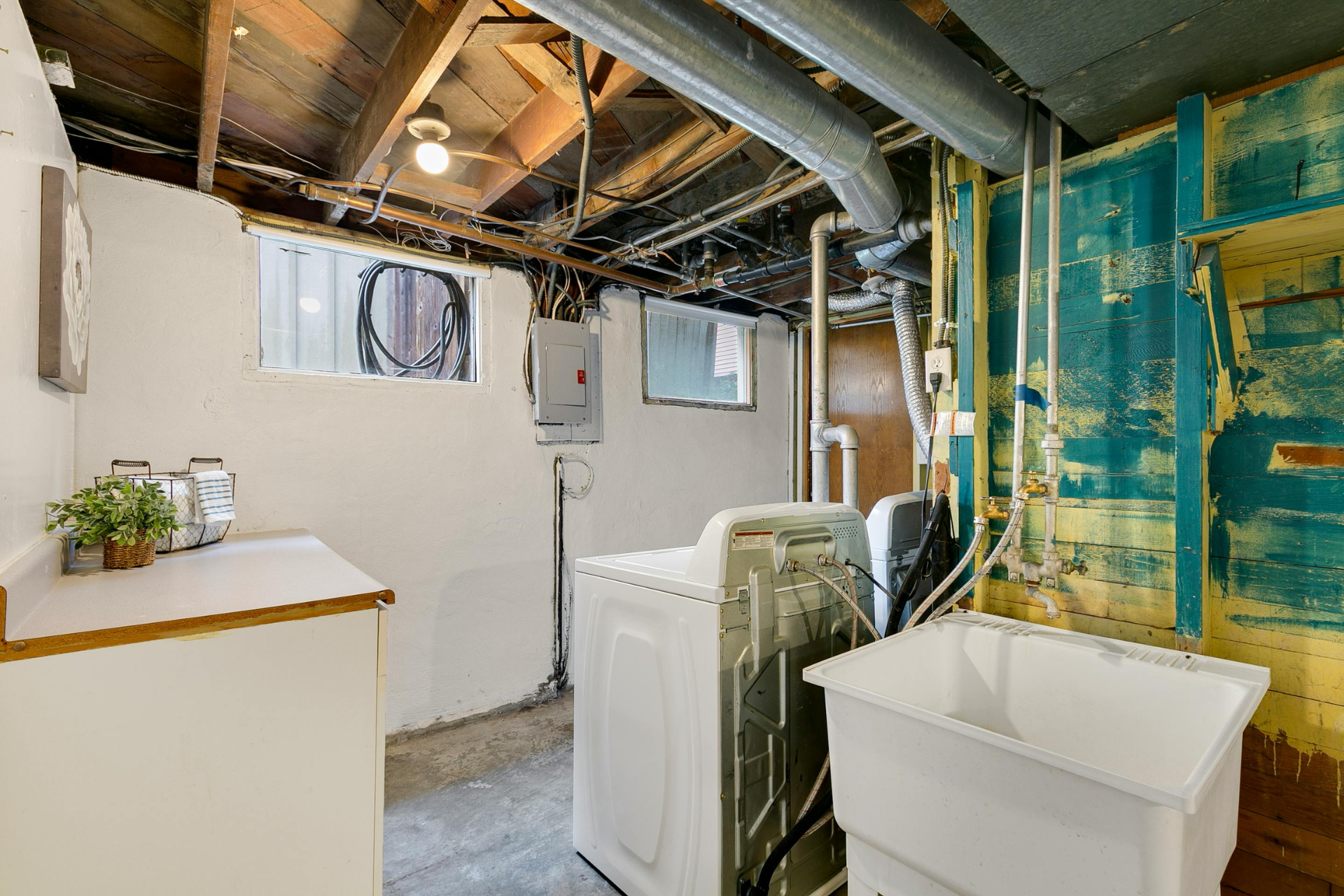 A laundry room with a washer and dryer and a sink.