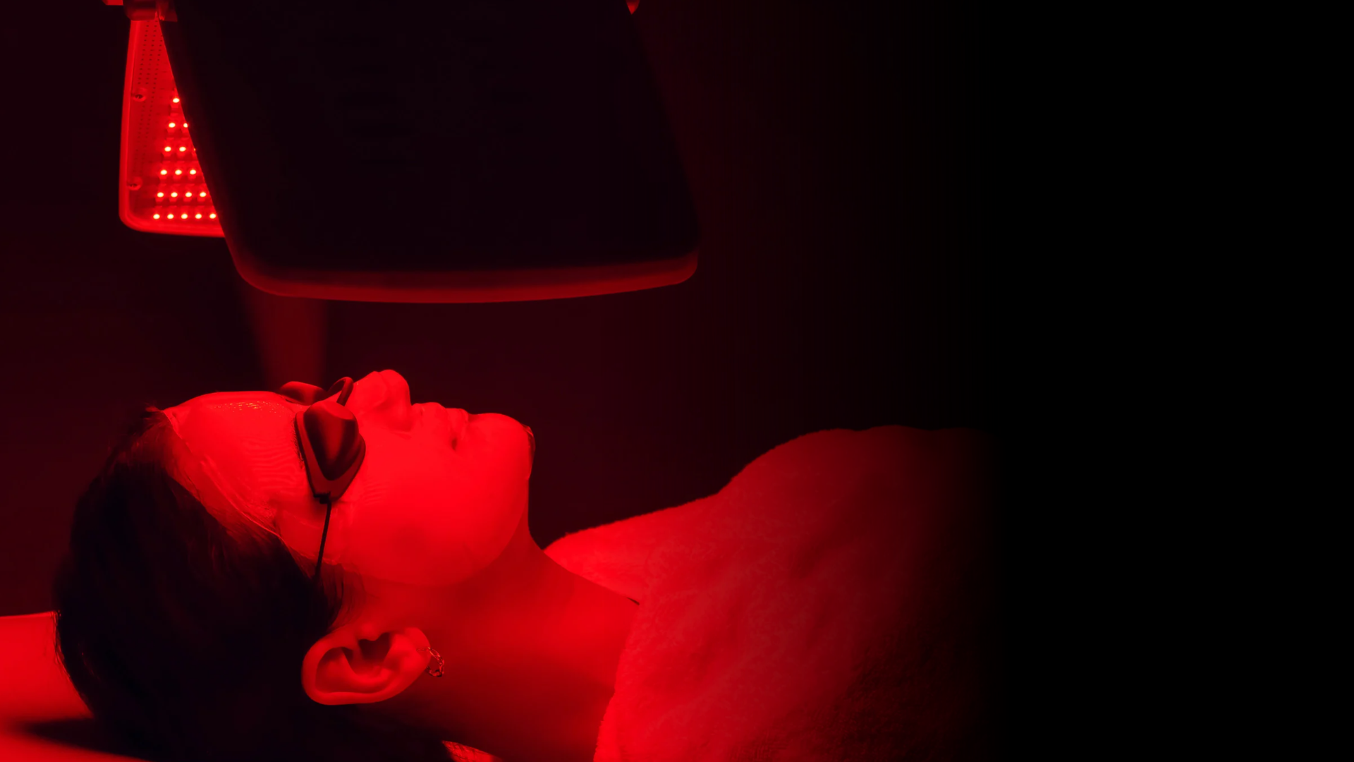 A woman relaxing under red light therapy