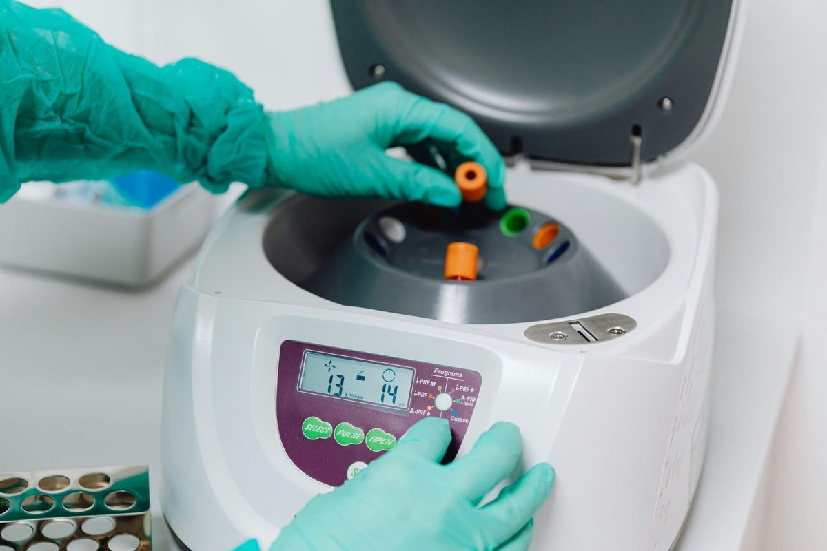 A lab technician loading samples into a centrifuge