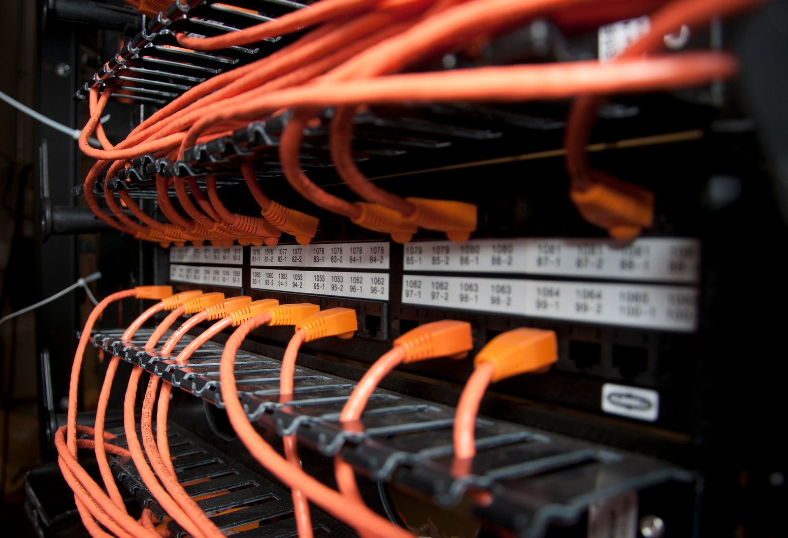 A bunch of orange wires are connected to a server.
