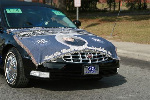 Black car with a decorative hood cover parked on a street