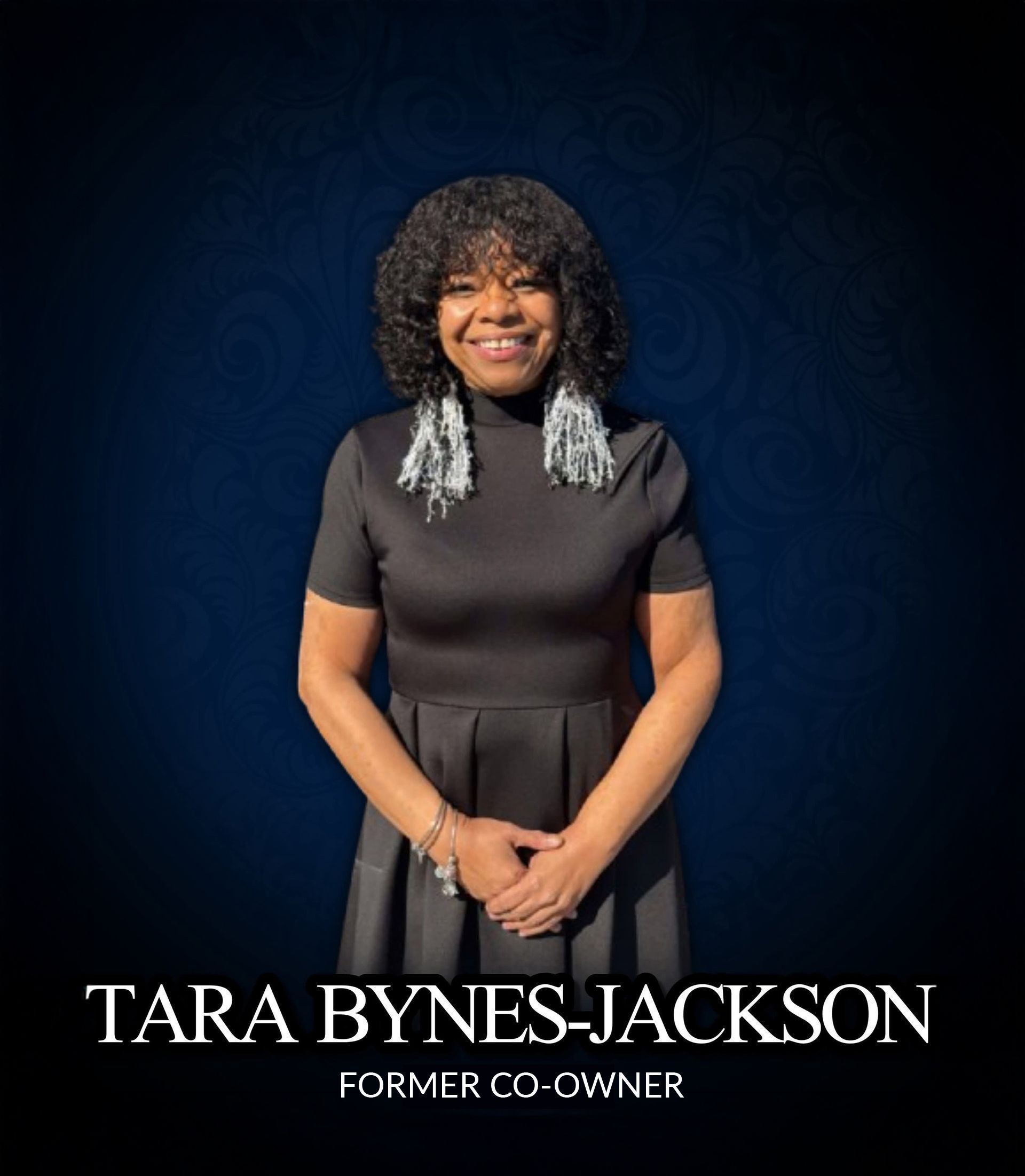 Portrait of Tara Bynes Jackson smiling in a black dress against a dark blue background