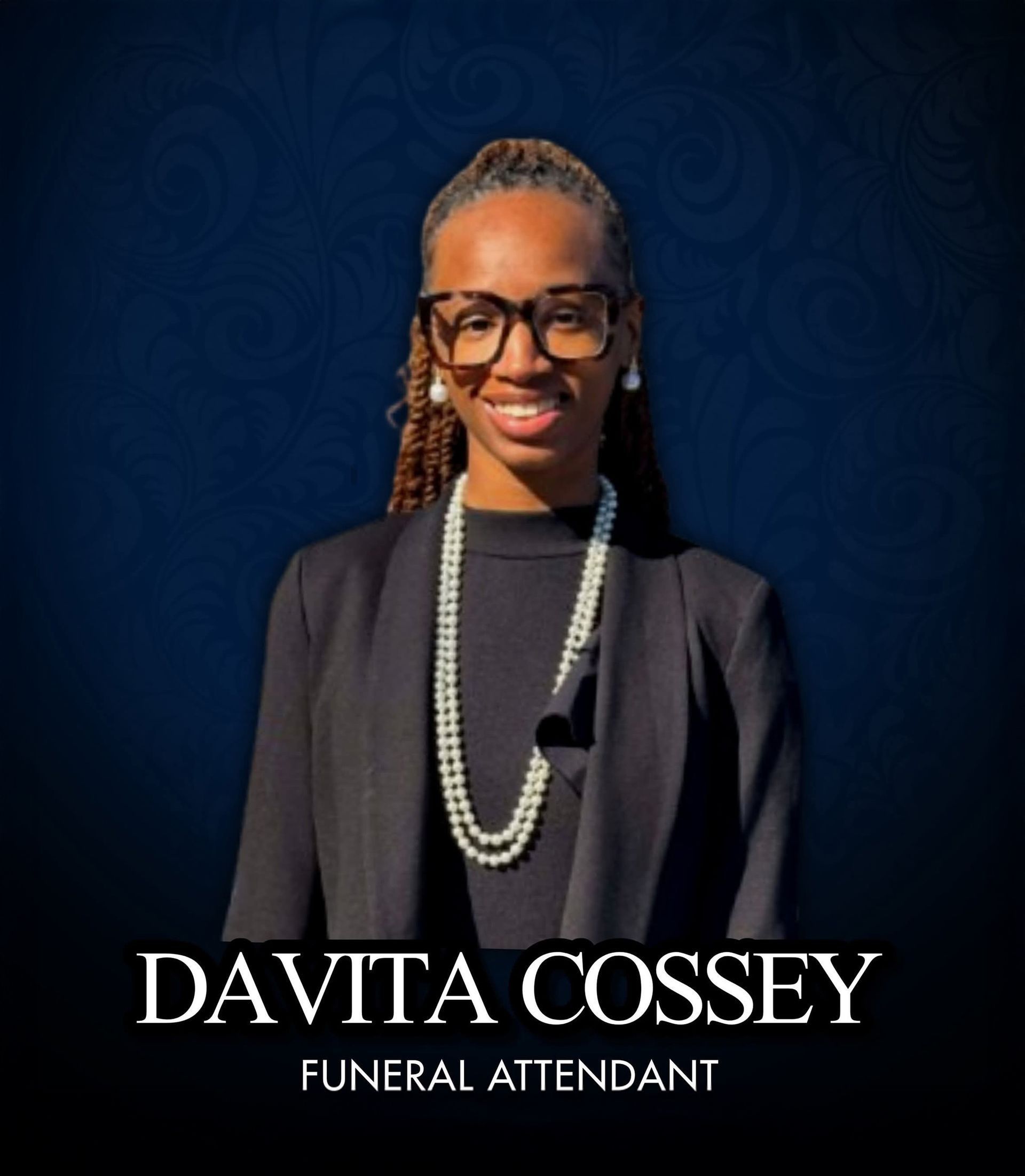 Portrait of Davita Cossey, funeral attendant, smiling in black attire against a dark blue background