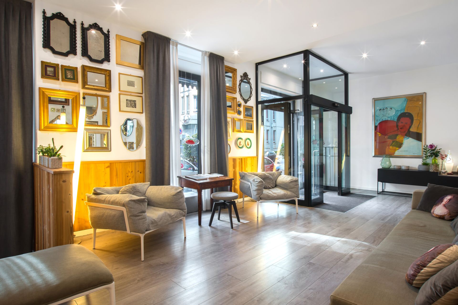 Vestíbulo de hotel con sofás, arte enmarcado y una puerta giratoria.