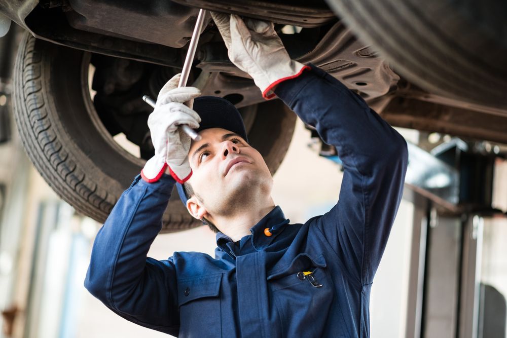 Mechanic Repairing a Lifted Car