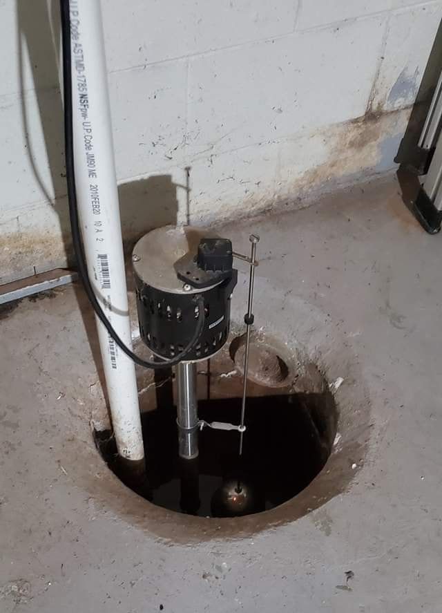 A sump pump in a concrete basin.