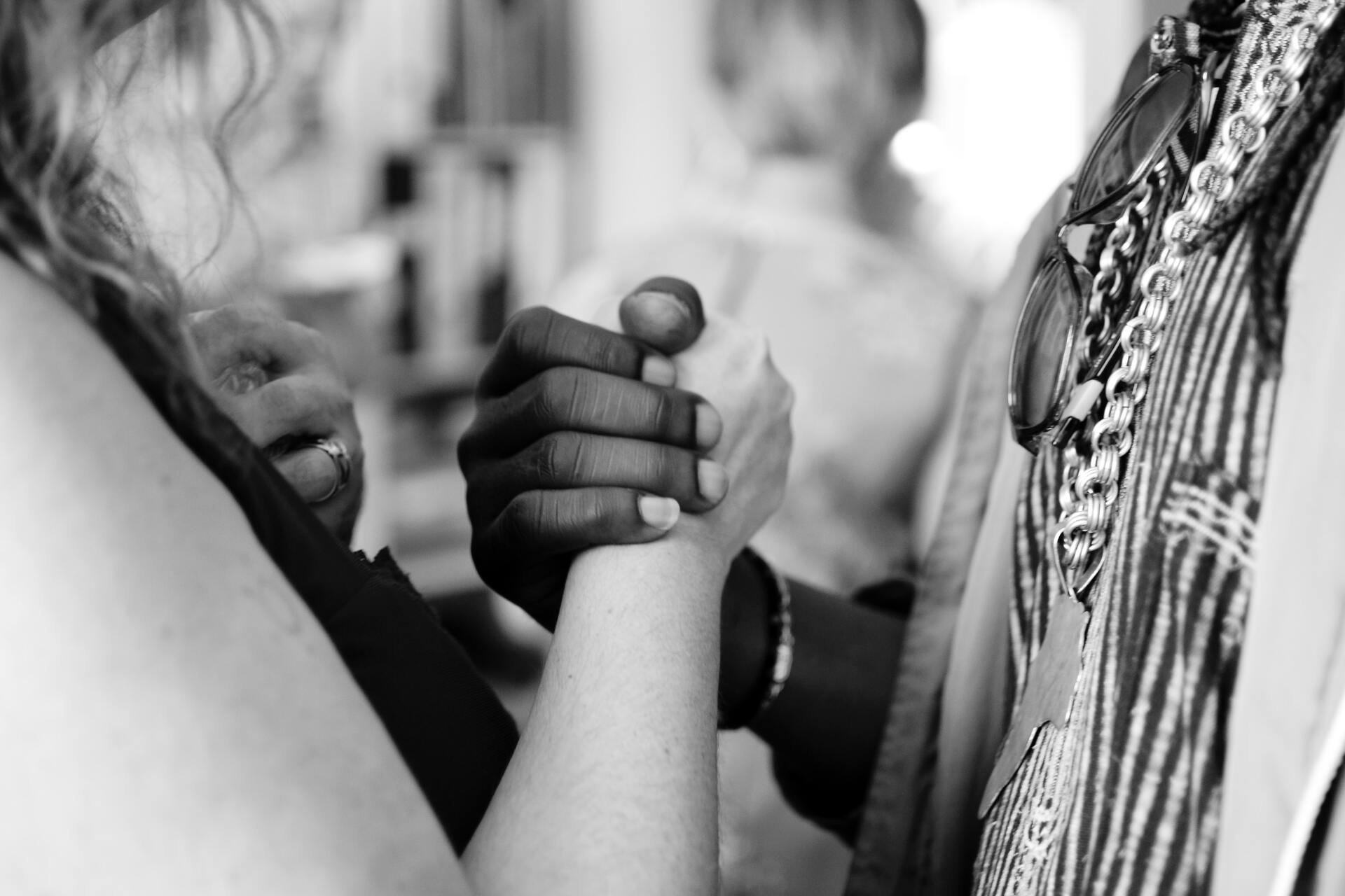 Two people arm wrestling, hands clasped, close-up.