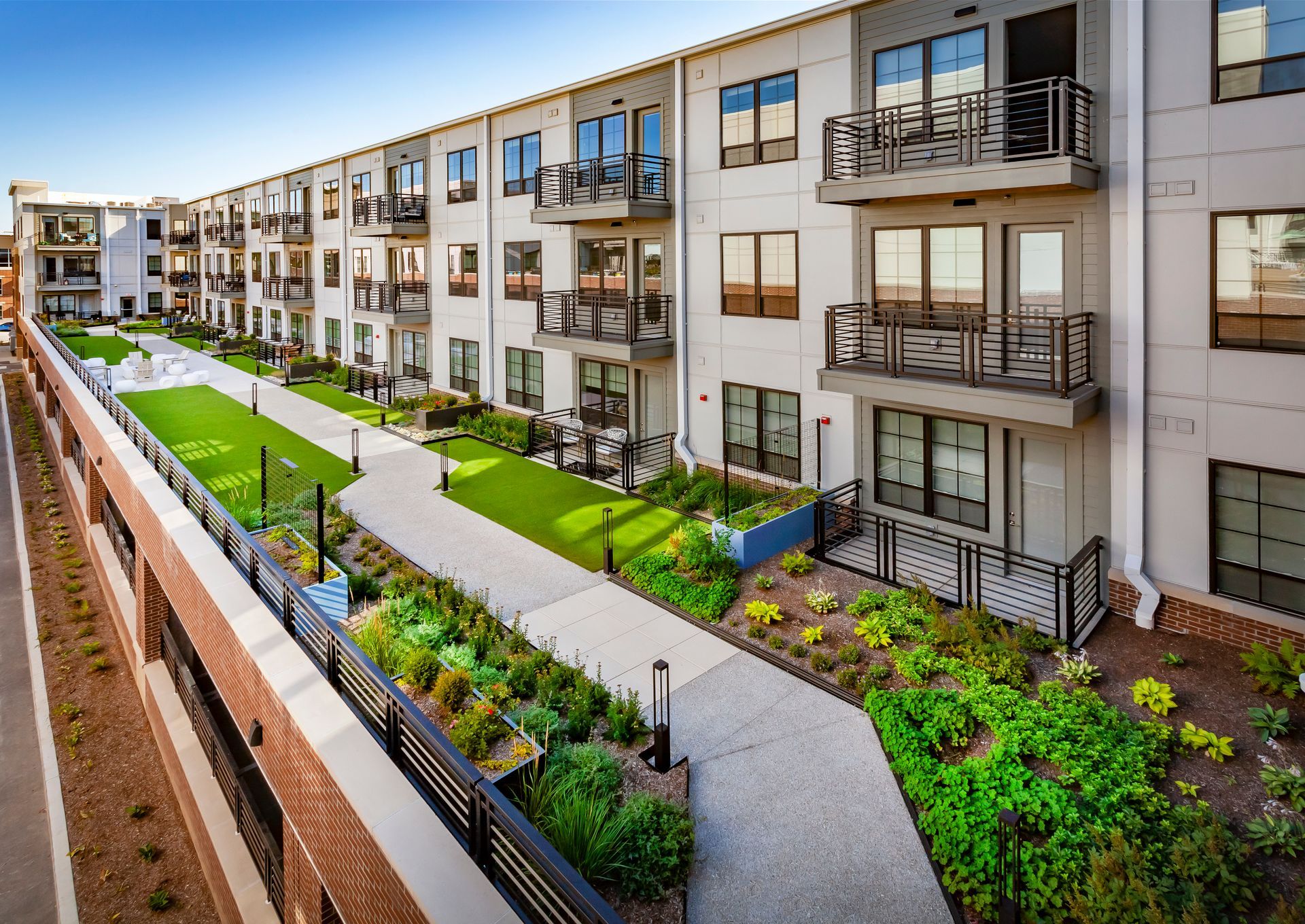 An aerial view of a large apartment building with a walkway leading to it at Nickel Plate.