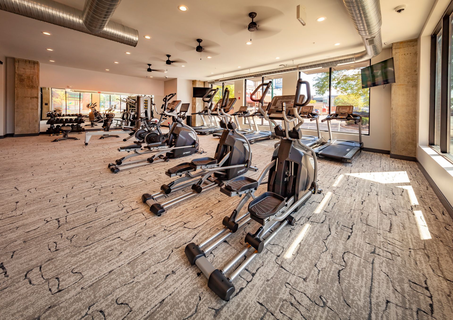 A large gym filled with lots of exercise equipment at Nickel Plate.