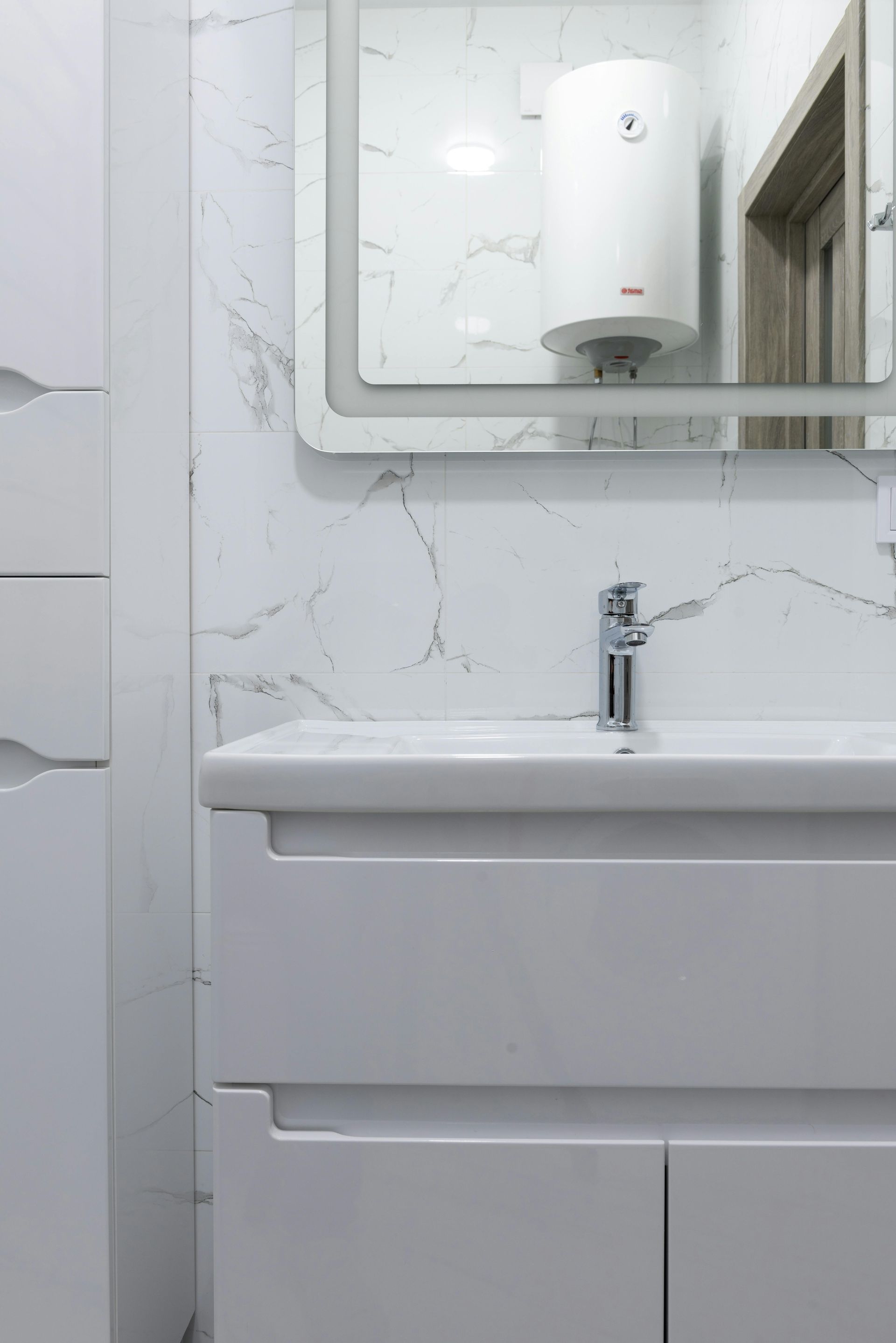 A bathroom with a sink , mirror and heater.