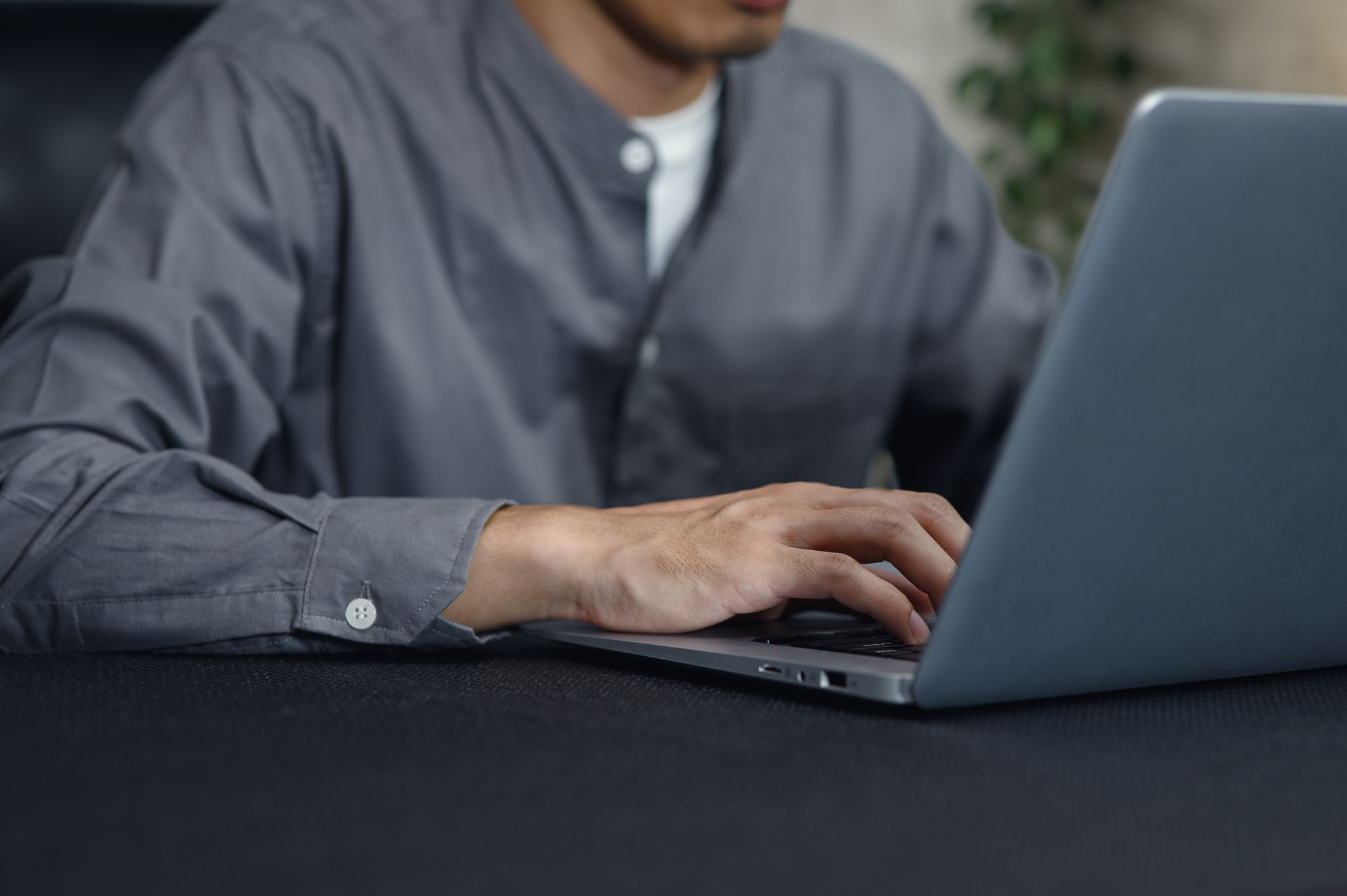 Person typing on a laptop at a table indoors