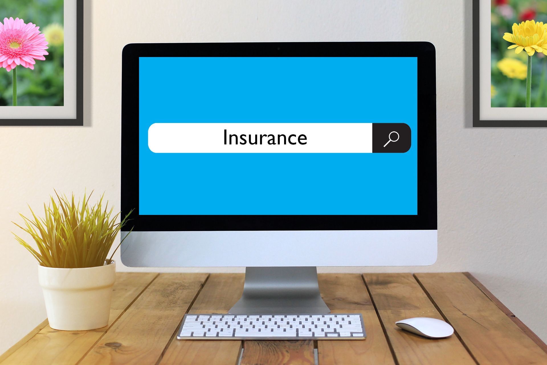 Desktop computer on a wooden desk showing an “Insurance” search bar on a blue screen