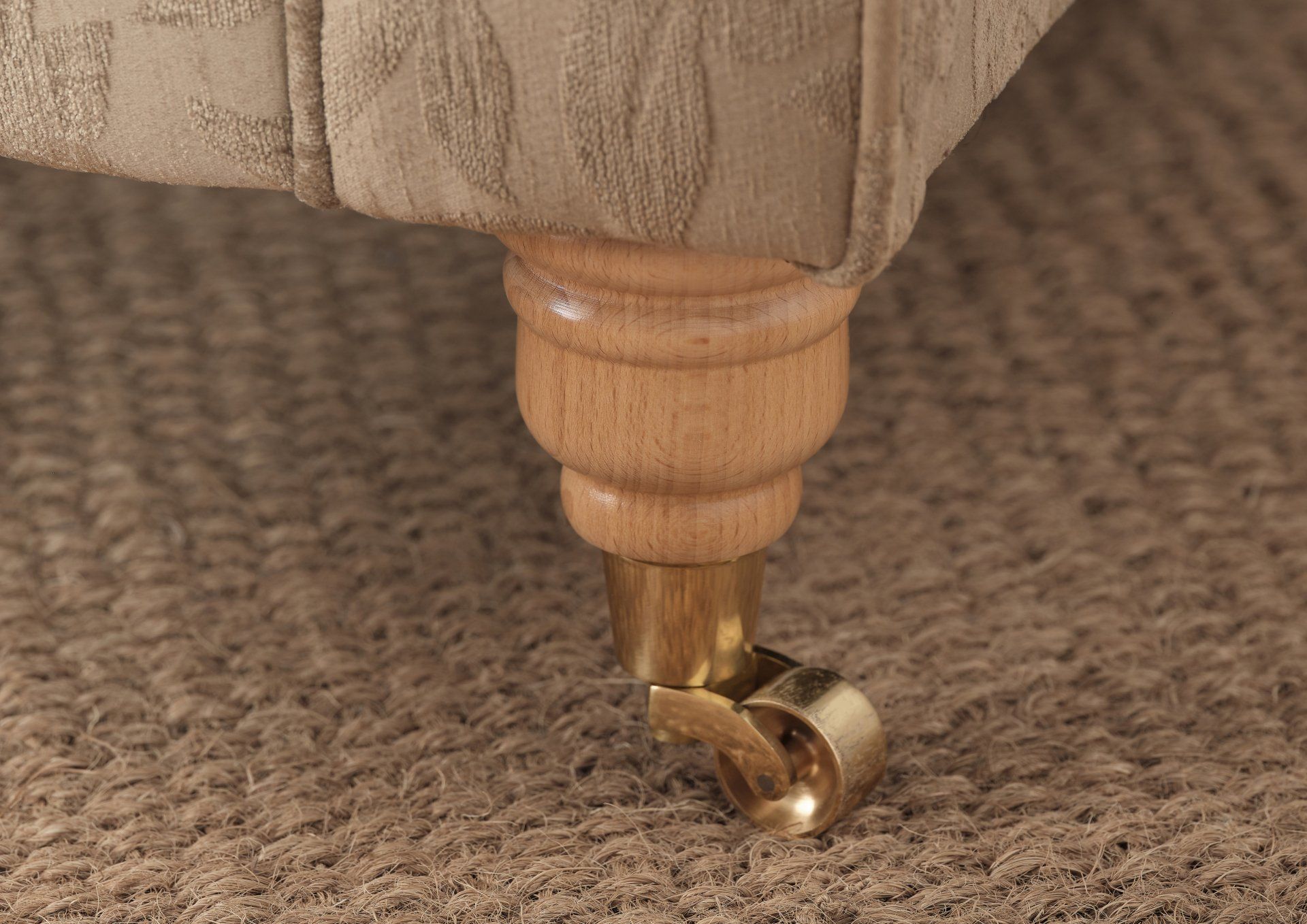 A close up of a wooden leg of a chair with wheels.
