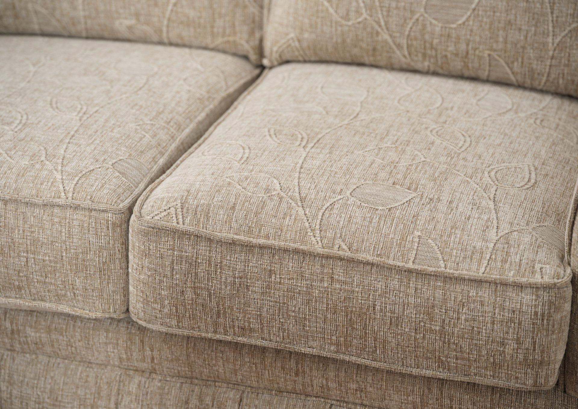 A close up of the back of a beige couch.