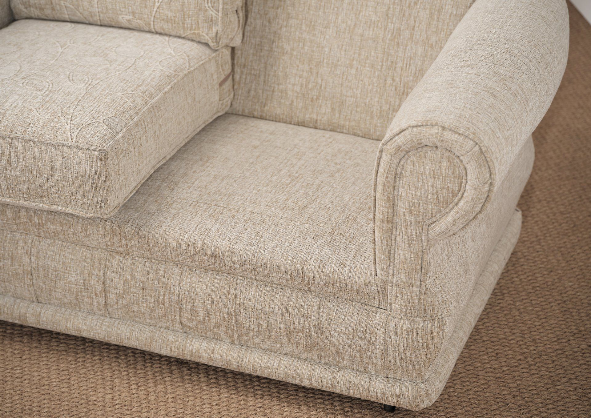 A close up of a beige chair on a carpet.