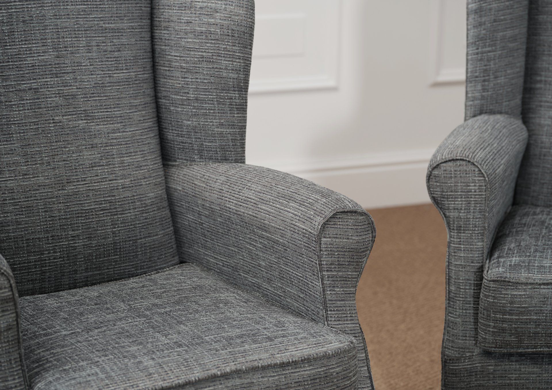 Two grey chairs are sitting next to each other in a living room.