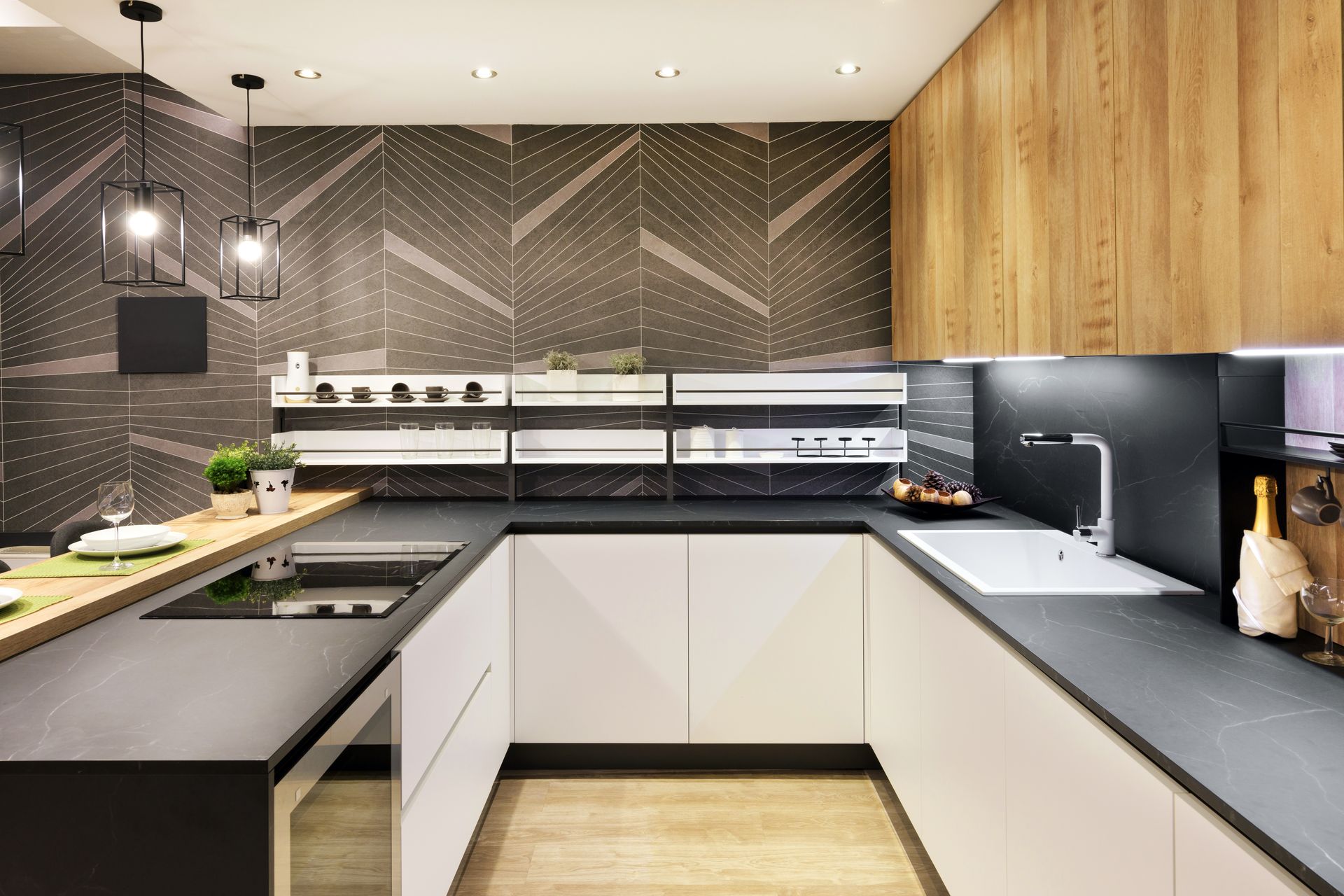 Modern kitchen with white cabinets, dark countertops, wood accents, and geometric patterned backsplash.