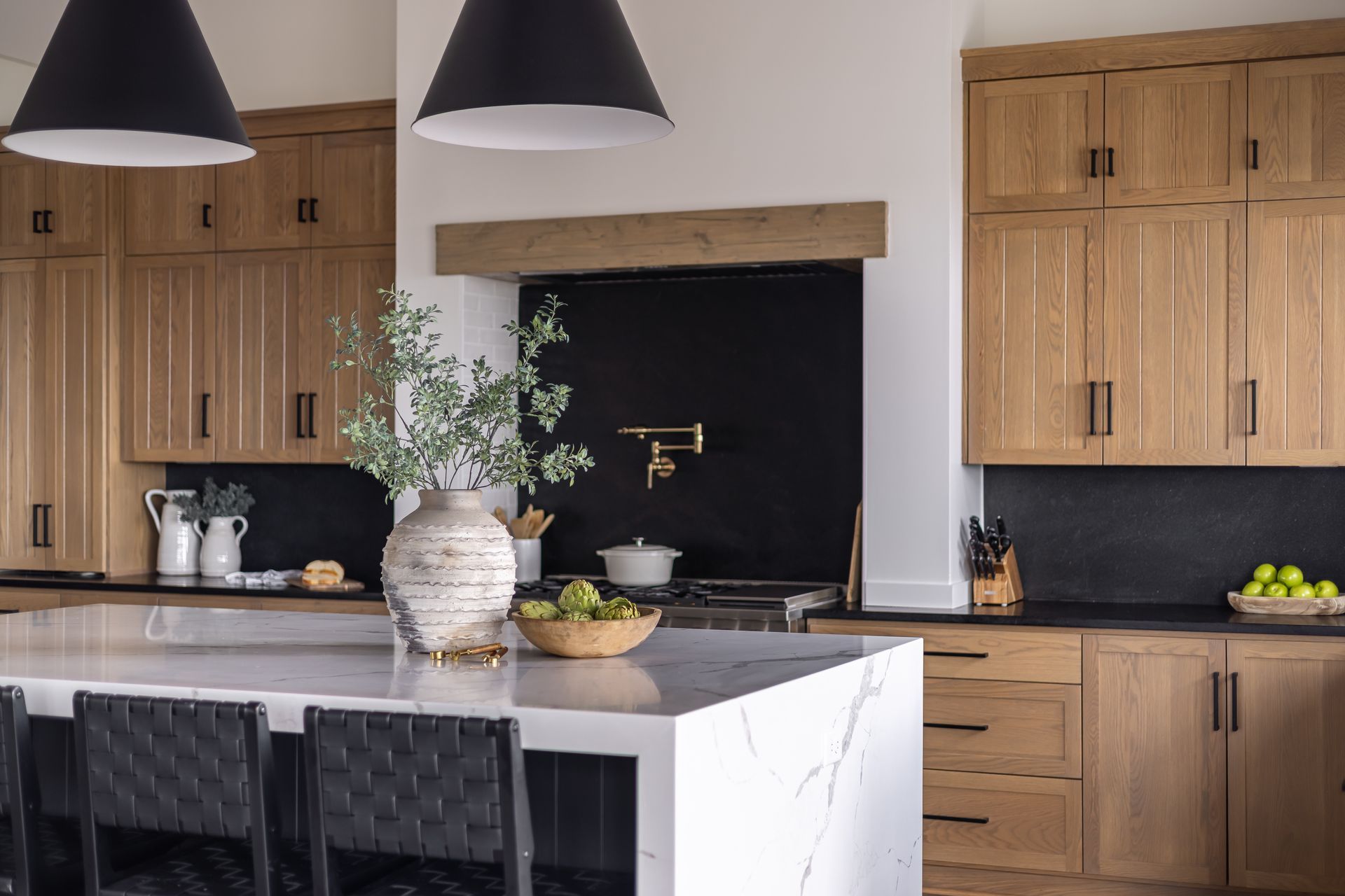 Modern kitchen with wooden cabinets, a black backsplash, and a white countertop island.