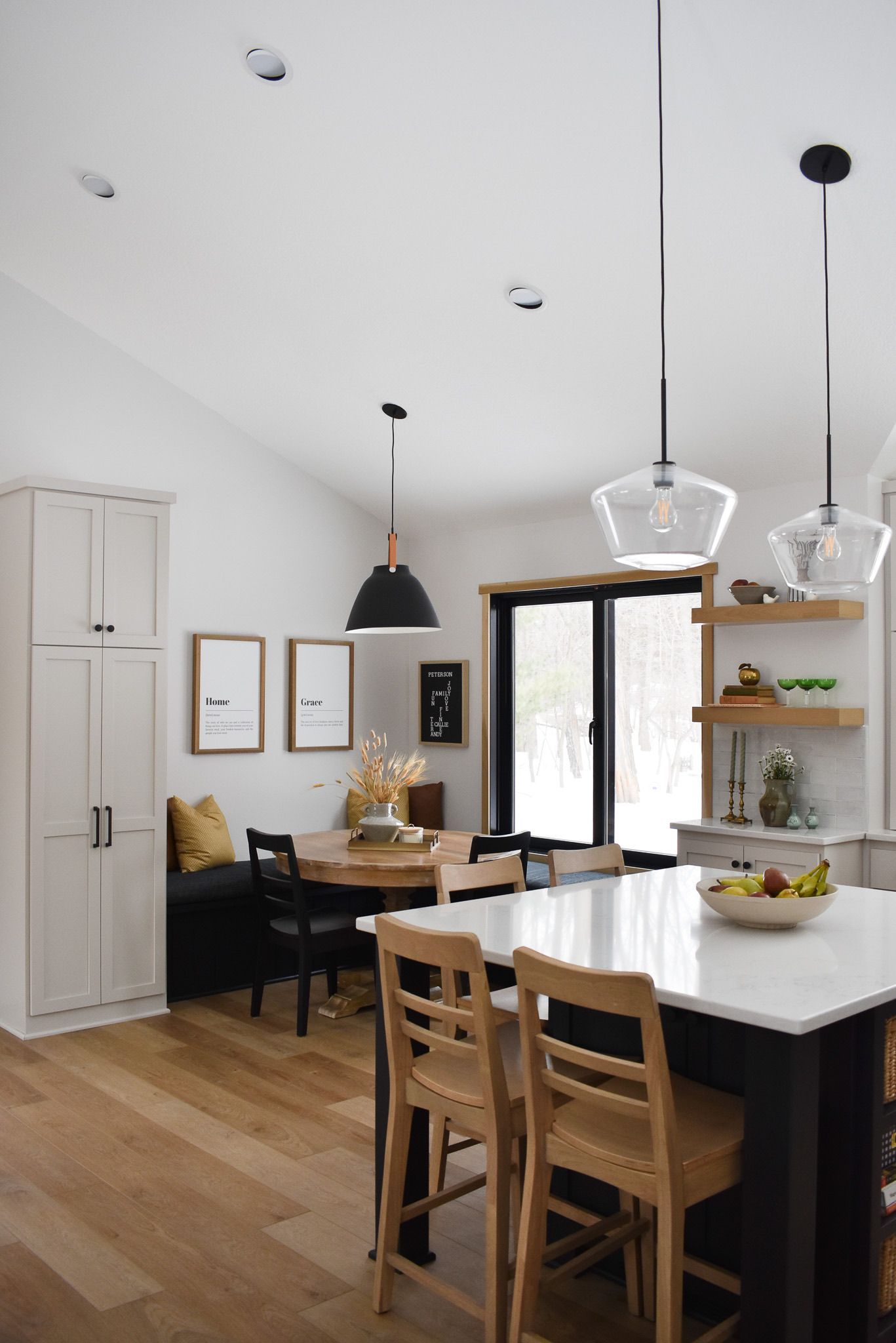 Modern kitchen with an island, dining table, and built-in bench seating.