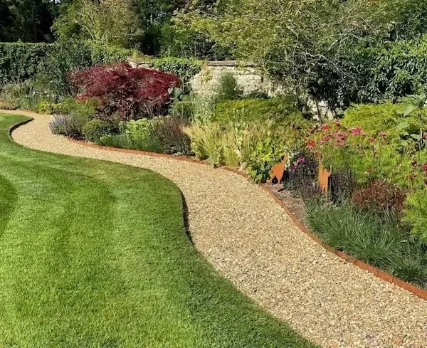 A gravel path runs through a lush green garden.