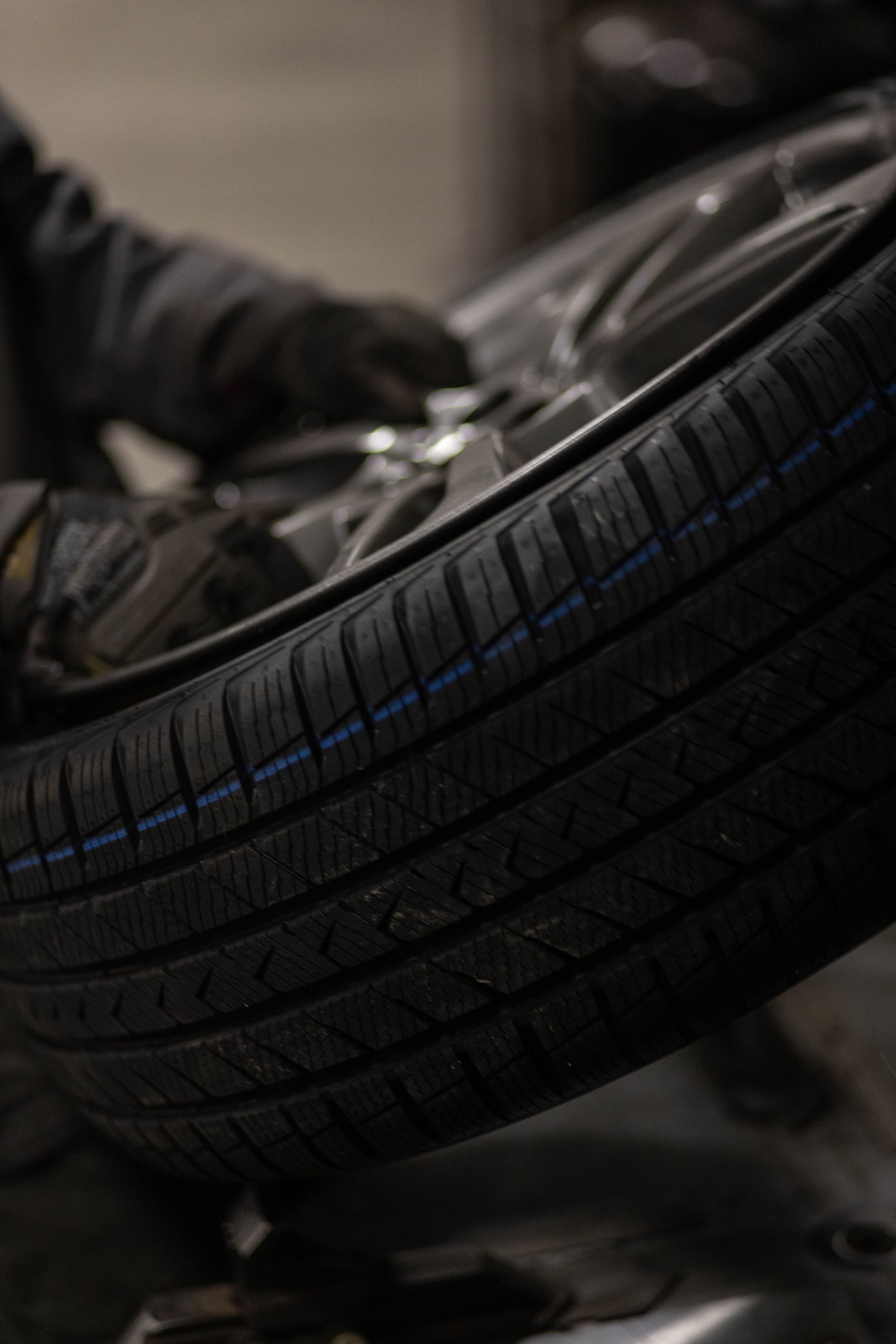 Close-up of a car tire being inspected or repaired by a mechanic in a garage